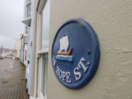 A sign displaying 18 Hope St with a boat depiction at Harbourside in Weymouth