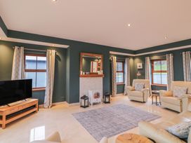 A living room with a television, fireplace, and seating at Ard Na Mara, Drung near Quigley's Point, County Donegal