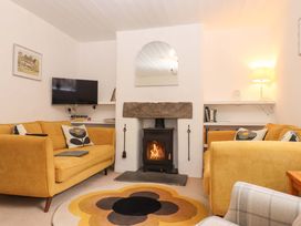 A living room with a fireplace and sofa at 2 New Mill Cottages in North Bovey
