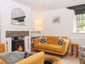 A living room with a fireplace and furniture at 2 New Mill Cottages North Bovey