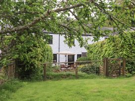 A garden with a house and seating at 2 New Mill Cottages North Bovey