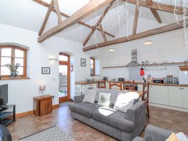 An open plan living room and kitchen with wooden beams on ceiling and grey sofa at The Yarde Annexe in Pen Elm near Taunton