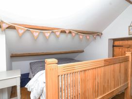 A bedroom with a wooden bed frame and a small side table at The Yarde Annexe in Pen Elm near Taunton