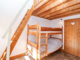 A bedroom with wooden bunk beds and a wooden staircase under a wooden beam ceiling at The Yarde Annexe in Pen Elm near Taunton