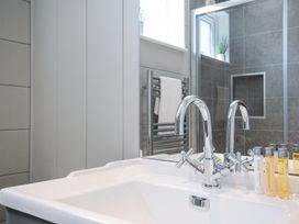 A bathroom sink with chrome faucets and toiletry bottles on the counter near a mirror and a towel rack at 17 Meadow Retreat in Dobwalls
