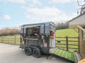 A mobile coffee bar trailer with the words gin tin on the side in an outdoor setting at Bell tent 3 Camerton near Timsbury