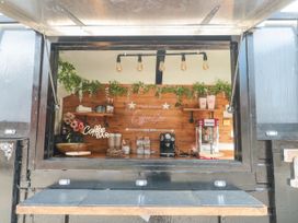 A coffee bar inside a black food truck with coffee machine popcorn maker and cups at Bell tent 3 Camerton near Timsbury