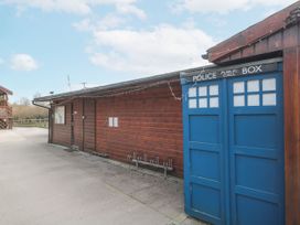 An outdoor area with a wooden building and a blue police public call box at Bell tent 3 Camerton near Timsbury