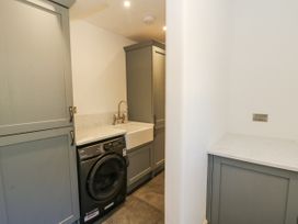 A laundry room with a washing machine and sink at Glanrannell Park House in Llanwrda