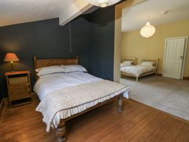 A bedroom with a wooden bed and nightstand at Glanrannell Park House in Llanwrda