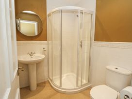 A bathroom with a shower, wash basin, and toilet at Glanrannell Park House in Llanwrda