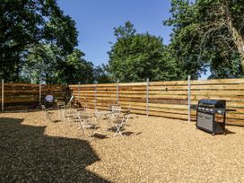 An outdoor space with chairs and a grill at Glanrannell Park House in Llanwrda