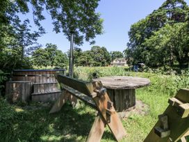 A garden with a hot tub and wooden table at Glanrannell Park House Llanwrda