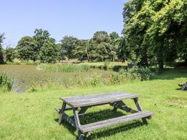A picnic table beside a pond at Glanrannell Park House in Llanwrda