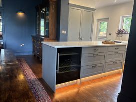 A kitchen with a kitchen island and wine cooler at The Retreat at Glanrannell Park House in Llansawel