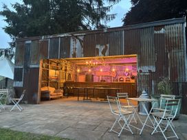 An outdoor bar with seating and a shed at The Retreat at Glanrannell Park House in Llansawel