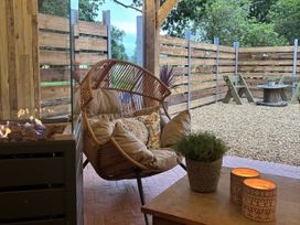 A seating area with a chair and table at The Retreat at Glanrannell Park House Llansawel