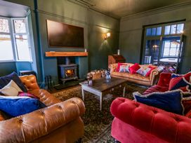 A living room with a fireplace and seating at The Retreat at Glanrannell Park House in Llansawel