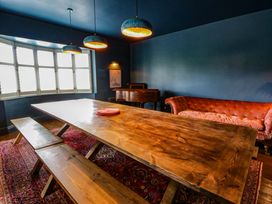 A dining room with a wooden table and bench at The Retreat at Glanrannell Park House in Llansawel