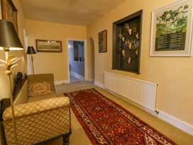 A hallway with a sofa and lamp at The Retreat at Glanrannell Park House in Llansawel
