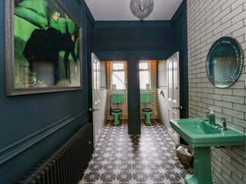 A bathroom with a sink and toilets at The Retreat at Glanrannell Park House Llansawel