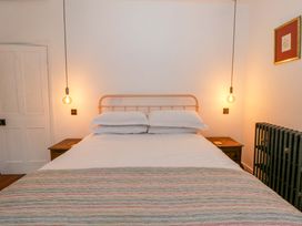 A bedroom with a bed and nightstand at The Retreat at Glanrannell Park House, Llansawel