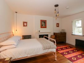 A bedroom with a bed, dresser, and radiator at The Retreat at Glanrannell Park House Llansawel