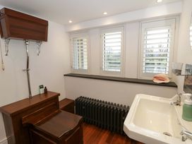 A bathroom with a sink and a radiator at The Retreat at Glanrannell Park House in Llansawel