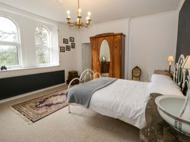 A bedroom with a bed and wardrobe at The Retreat at Glanrannell Park House in Llansawel