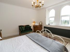 A bedroom with a bed and a sofa at The Retreat at Glanrannell Park House in Llansawel