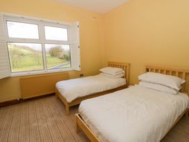 A bedroom with two single beds and a large window at The Retreat at Glanrannell Park House in Llansawel