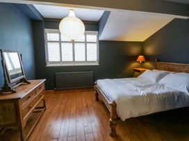 A bedroom with a bed, mirror, and window at The Retreat at Glanrannell Park House in Llansawel