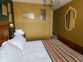 A bedroom with a bed and wall decor at The Retreat at Glanrannell Park House in Llansawel