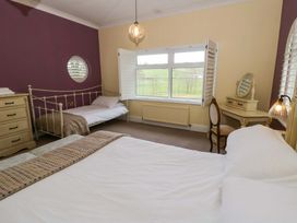 A bedroom with two beds and a window at The Retreat at Glanrannell Park House in Llansawel