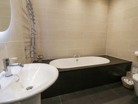 A bathroom with a bath tub and sink at The Retreat at Glanrannell Park House in Llansawel