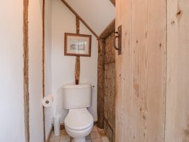 A small bathroom with a toilet and wooden door at The Round House in Wardington near Chacombe