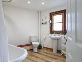 A bathroom with a toilet sink bathtub and wooden framed window at The Round House in Wardington near Chacombe