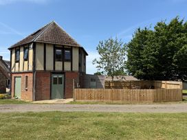 A round building with a fence and trees at The Round House Wardington near Chacombe