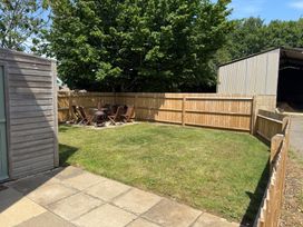 A garden with outdoor seating and a fire pit at The Round House in Wardington near Chacombe