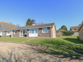 A single-story brick house with a tiled roof and front lawn and driveway at Lighthouse View in Winterton-On-Sea