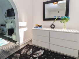 A living room with a dresser and flowers at Anfield Stadium House Liverpool