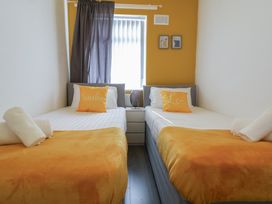 A bedroom with two single beds and a lamp at Anfield Stadium House in Liverpool