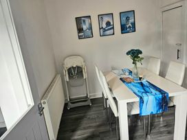 A dining room with a table and flowers at Anfield Stadium House in Liverpool