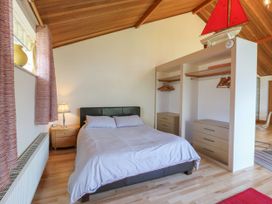 A bedroom with a bed side table lamp and built in wardrobes at Studio Cottage in Surlingham near Poringland