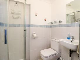 A bathroom with a shower, toilet, and sink with soap at Studio Cottage Surlingham near Poringland