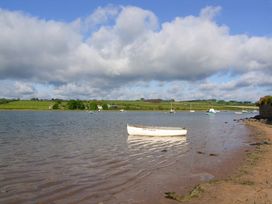 A river with a boat and green hills at Seafield Granary Alnmouth