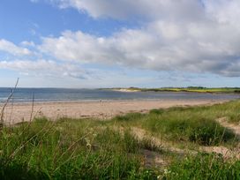 A beach with sand and water at Seafield Granary Alnmouth