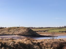A view with a hill and cross near water at Seafield Granary Alnmouth