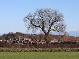 A view of a tree and houses in the background at Seafield Coach House Alnmouth