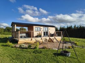An outdoor area with a shepherd's hut and deck at Fir Tree Shepherd's Hut, Llanon
